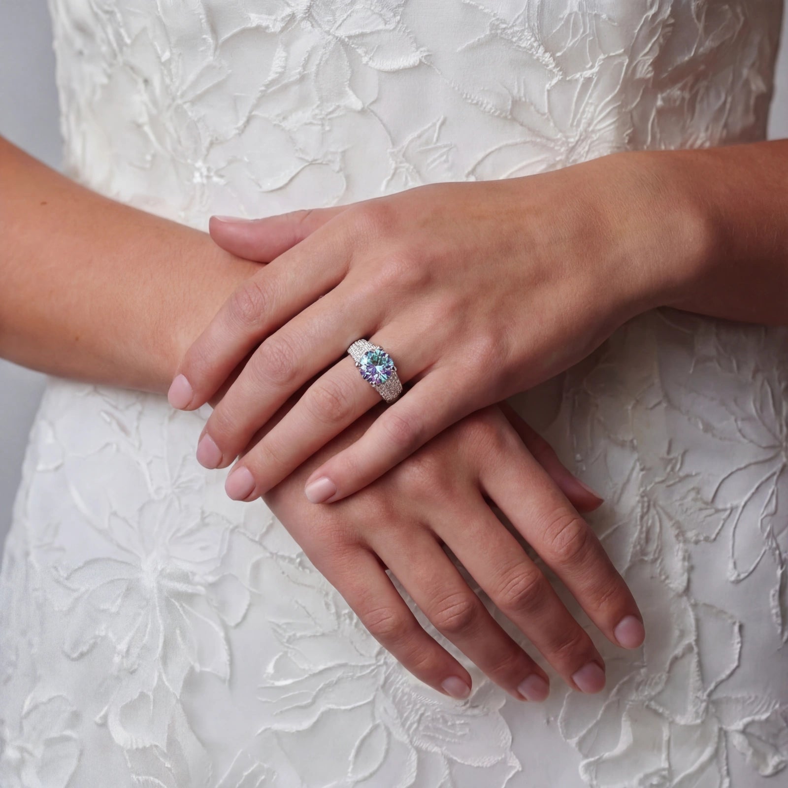 Close-up of hands with a ring on a textured white background