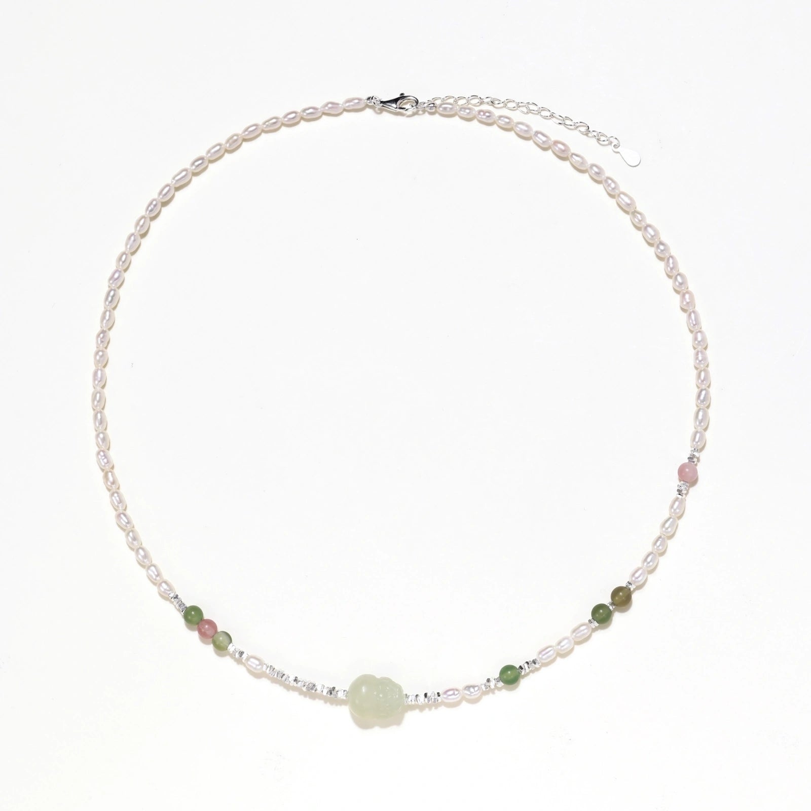 Delicate pearl necklace with pale green serpentine jade centerpiece and colorful agate beads on cream background