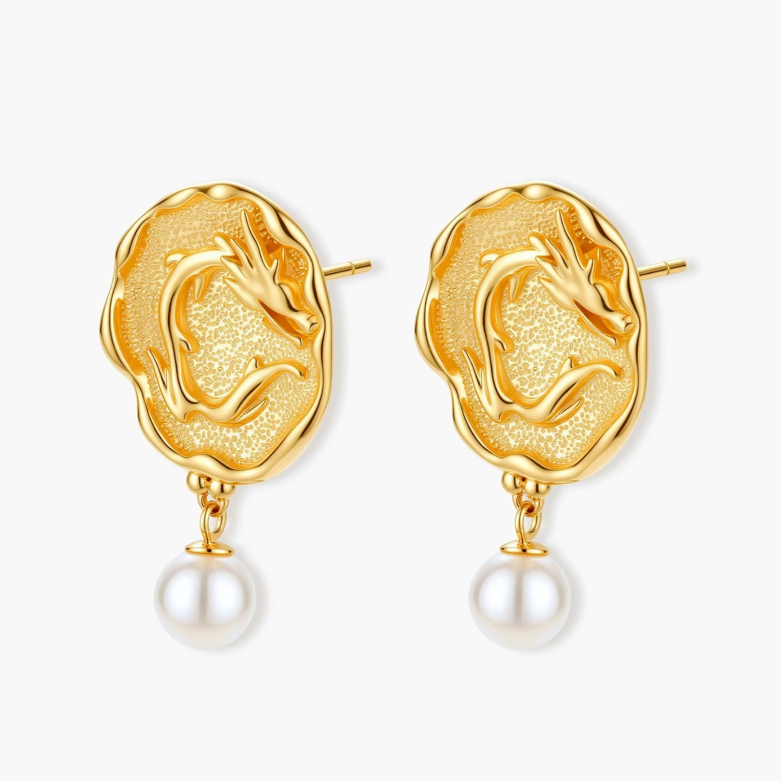 Ornate gold-plated dragon medallion earrings with white shell pearl drops on beige background, featuring detailed Chinese motifs.