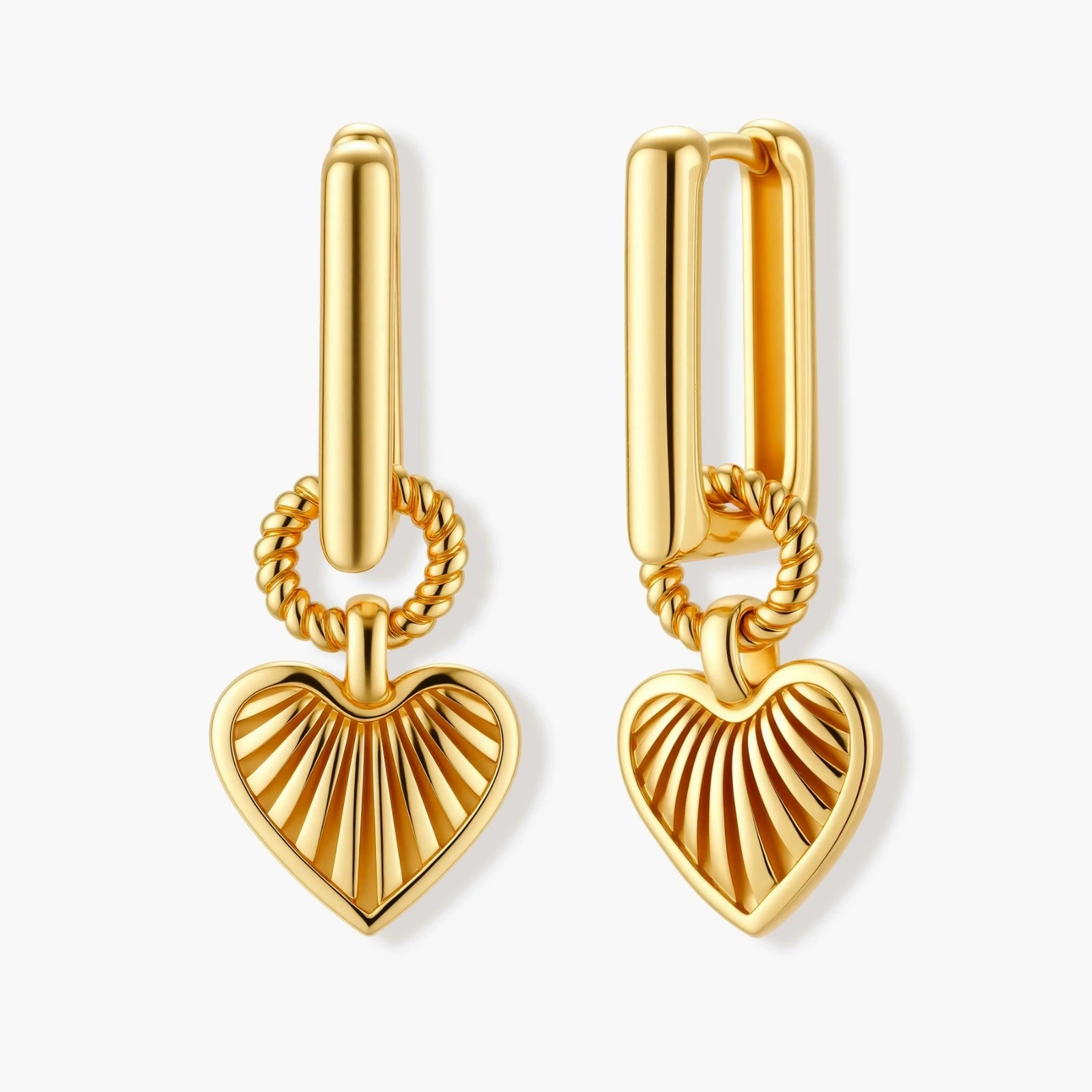 Gold-plated huggie earrings with textured heart charms featuring radiating sunburst patterns on white background.