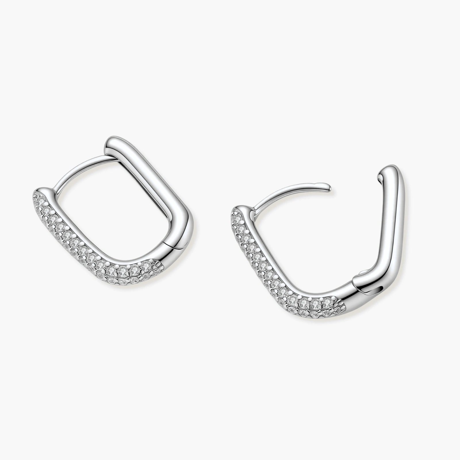 Close-up of platinum-plated sterling silver huggie hoops with pavé crystal setting on white background.