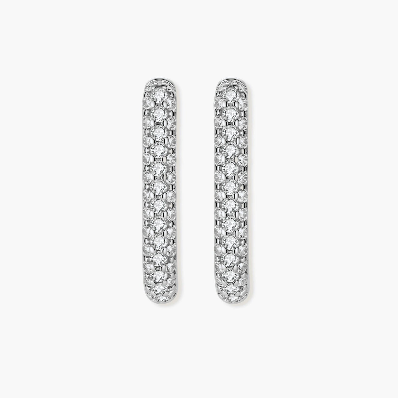 Close-up of platinum-plated sterling silver huggie hoops with pavé crystal setting on white background.