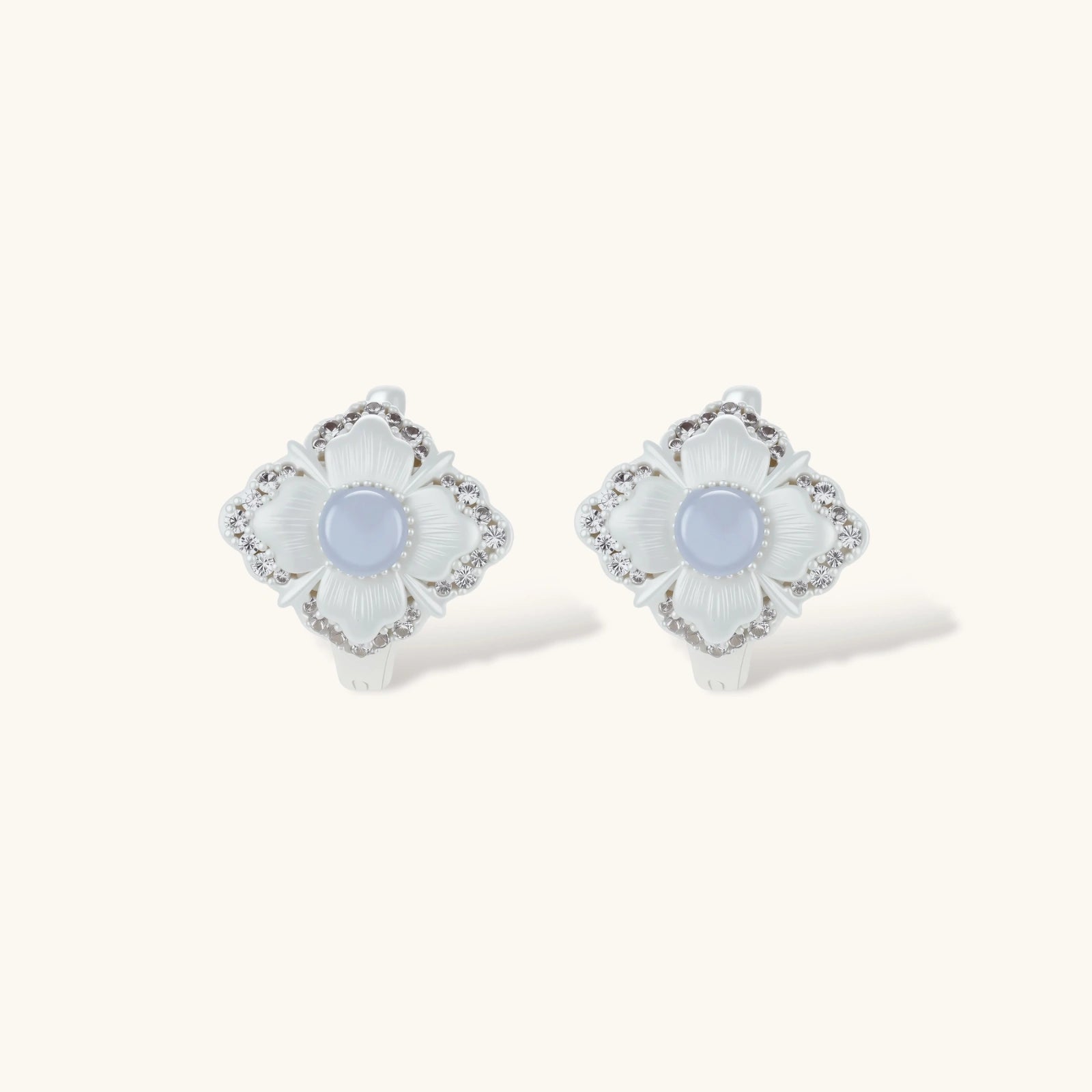 Silver-plated flower earrings with blue zirconia centers, featuring one stud and one huggie hoop in mismatched pair style.