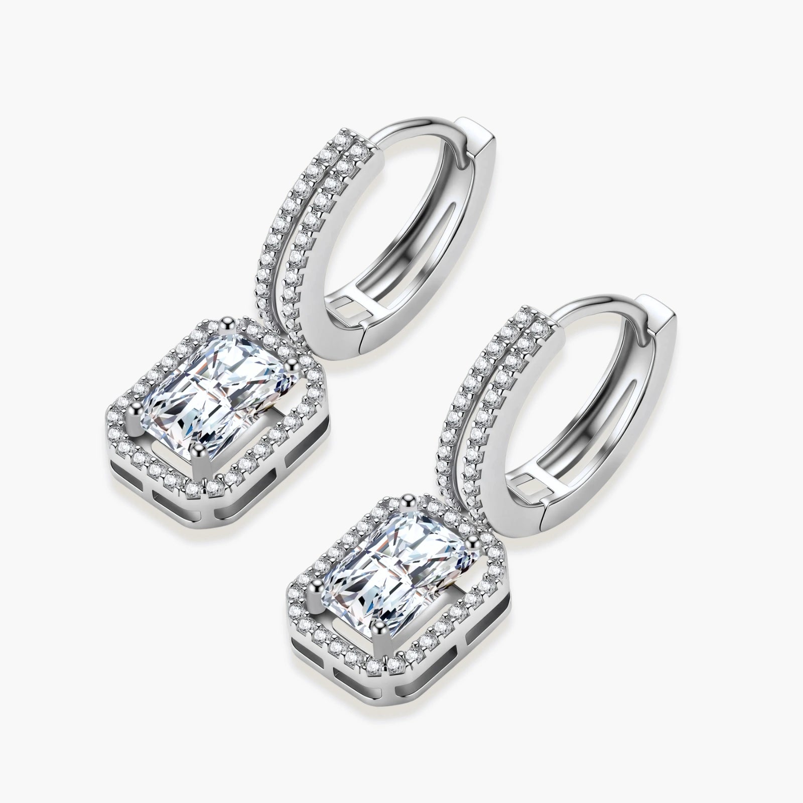 Sterling silver huggie hoops with emerald-cut moissanite drops featuring pavé-set crystals on white background.
