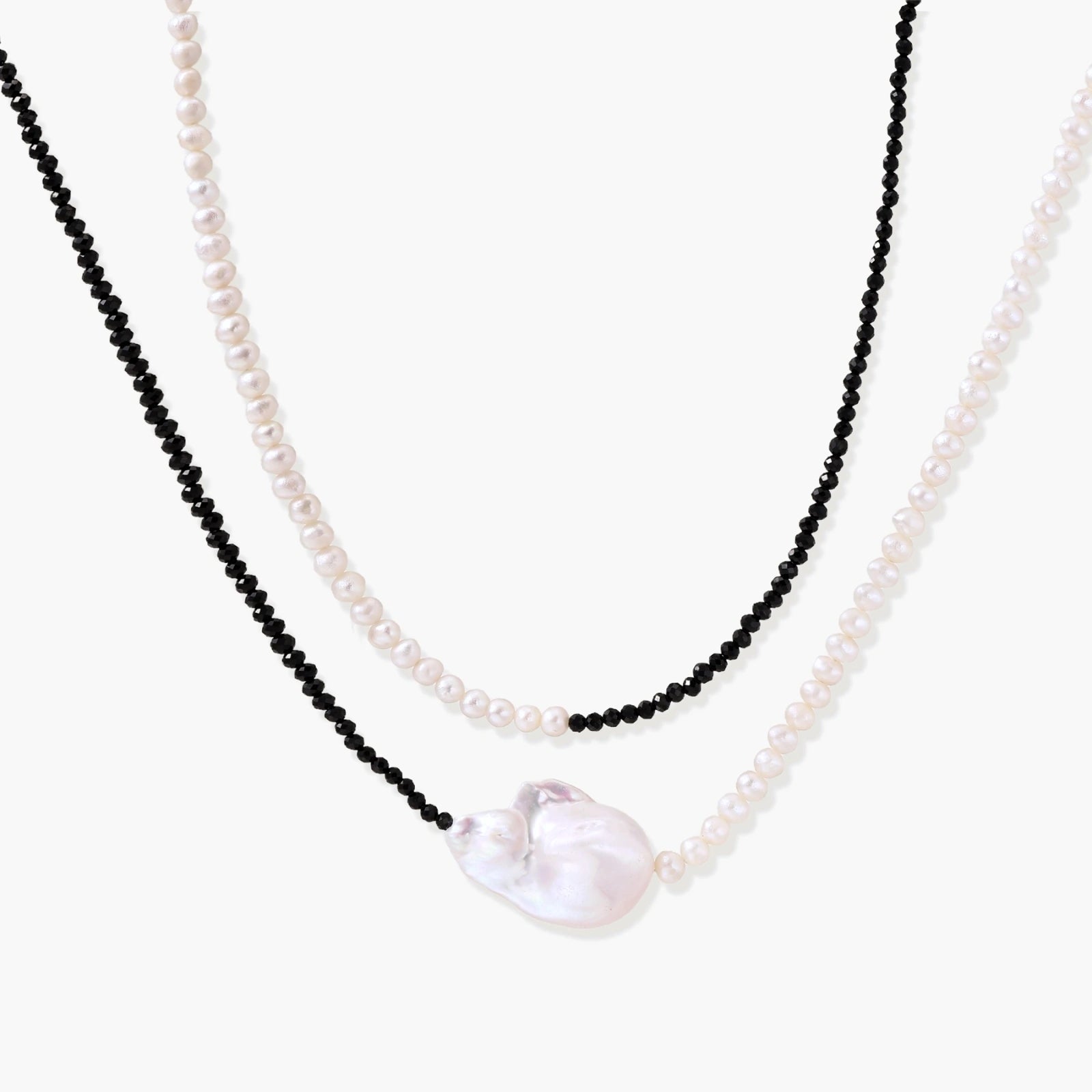 Double-strand necklace with black faceted quartz and white pearls featuring an oversized baroque pearl centerpiece