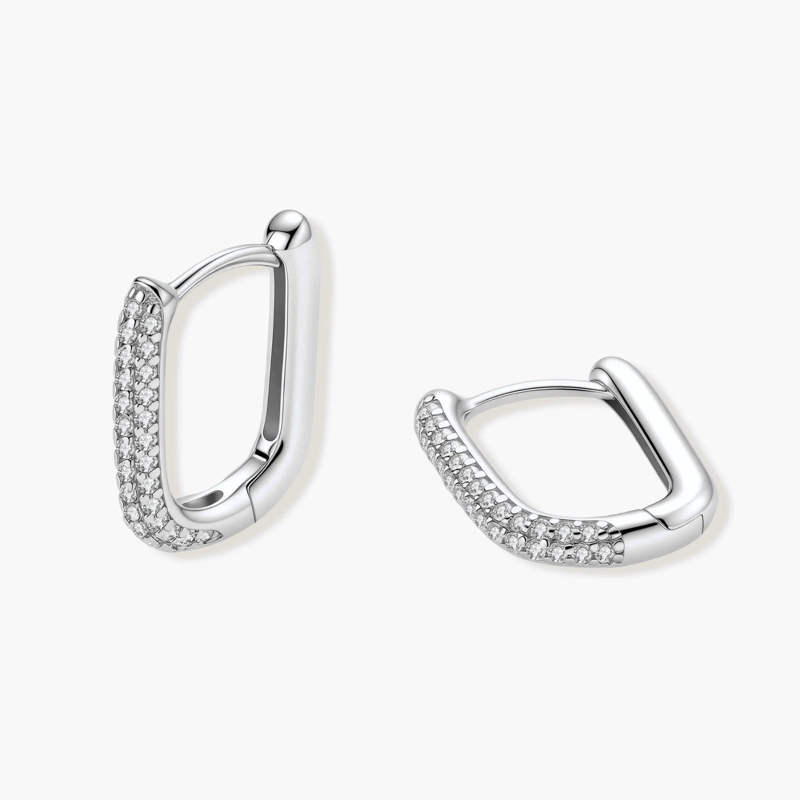 Close-up of platinum-plated sterling silver huggie hoops with pavé crystal setting on white background.