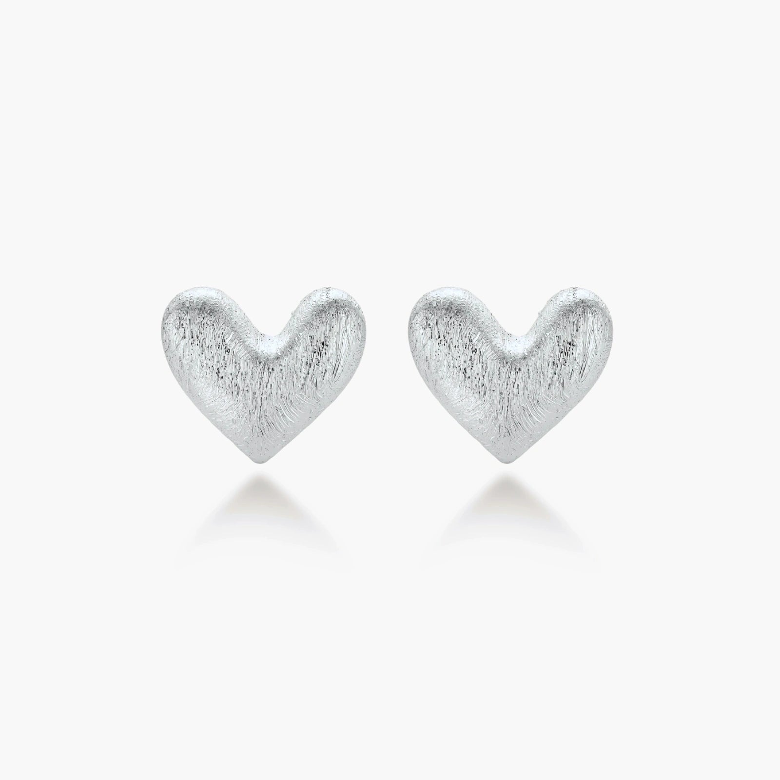 Pair of brushed platinum-plated 925 sterling silver puffy heart stud earrings on a cream background.