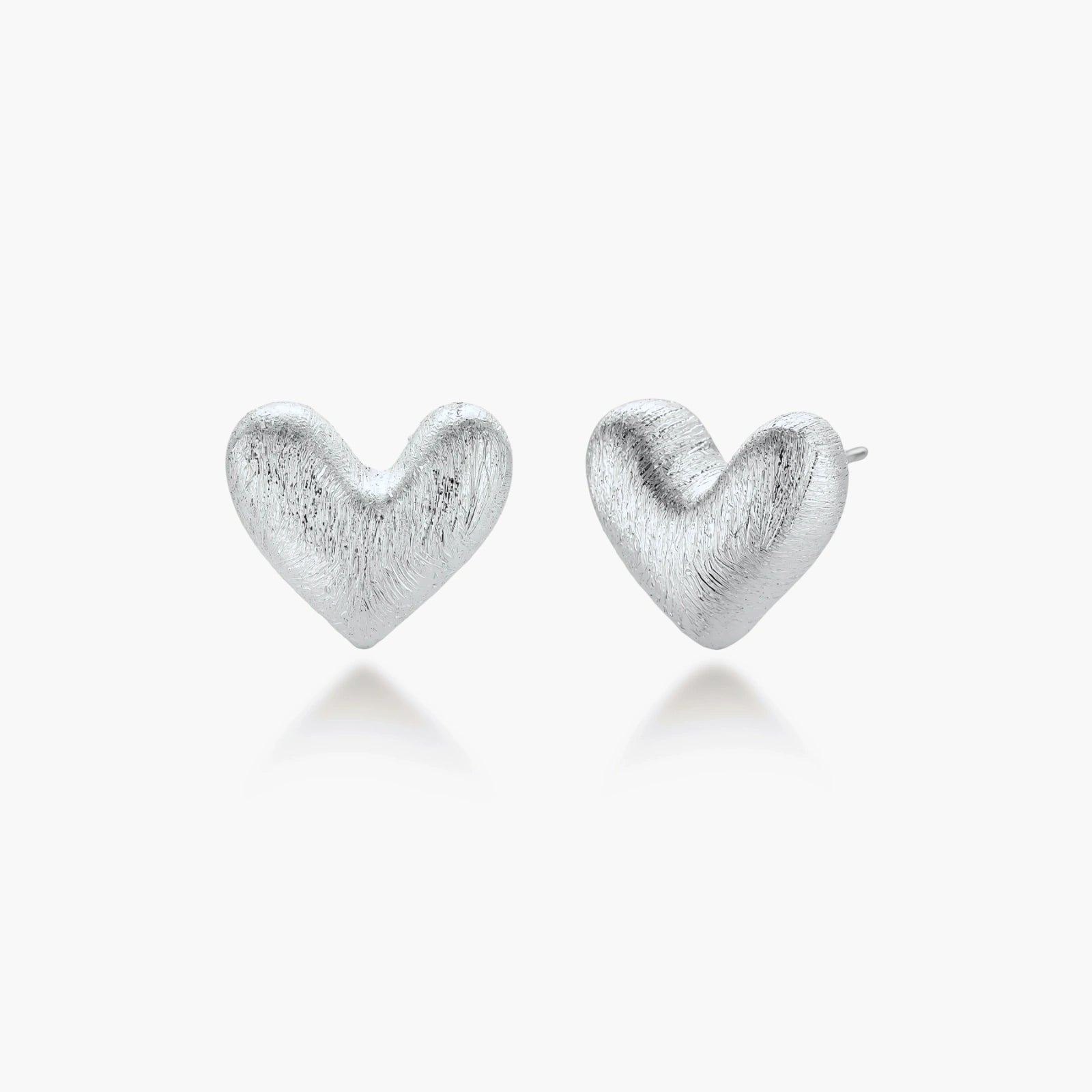 Pair of brushed platinum-plated 925 sterling silver puffy heart stud earrings on a cream background.