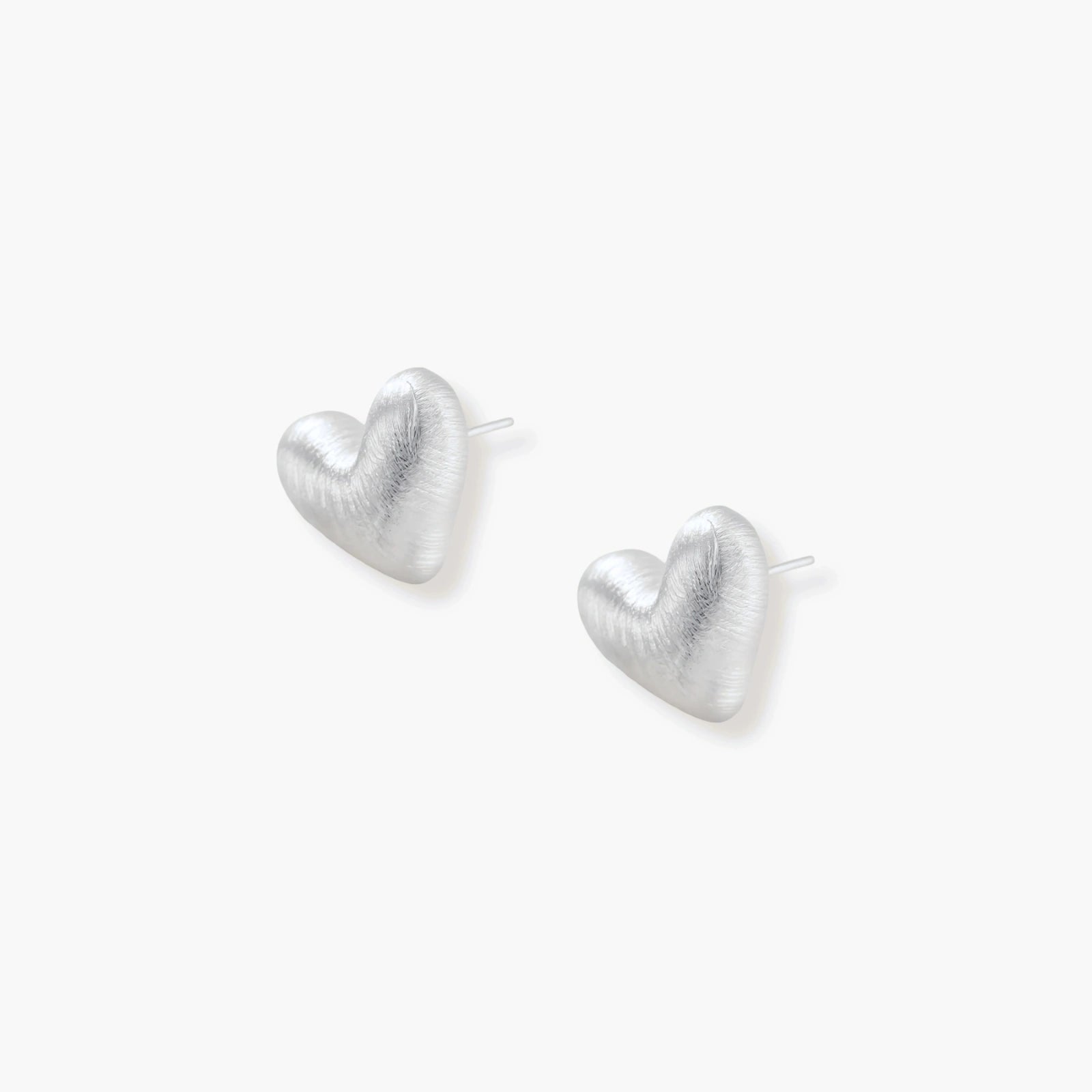 Pair of brushed platinum-plated 925 sterling silver puffy heart stud earrings on a cream background.