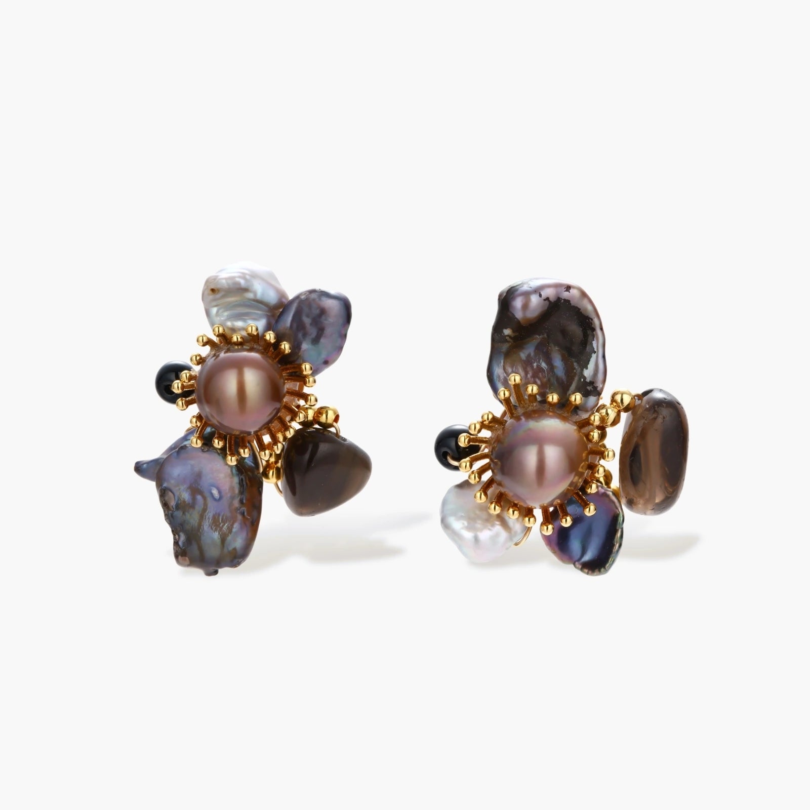 Dark baroque pearl cluster earrings with gold sunburst centers arranged in organic floral design on cream background.
